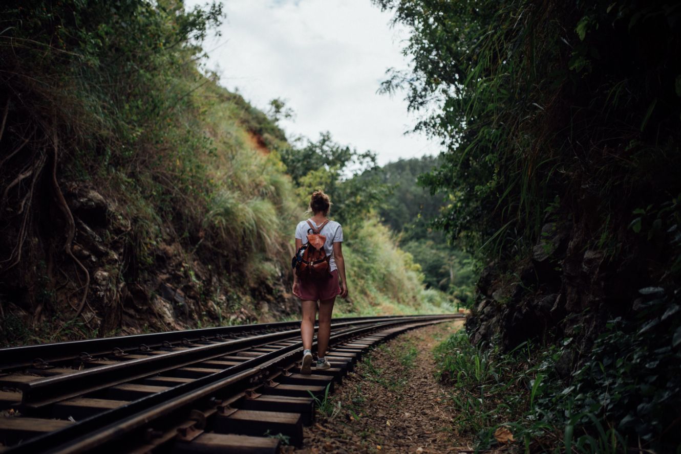 girl walking on abandoned railroad